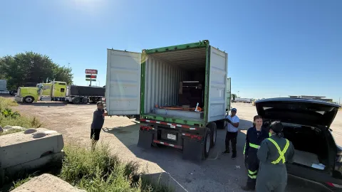 The crew works to load boxes of ultrapure copper into a shipping container with a thick steel box for shielding.