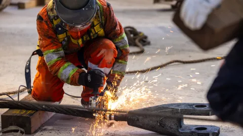 Ross Shaft Crews work alongside technicians at Fortis Mining Engineering & Manufacturing Company on the rope change.   Here a technician cuts the wire rope about to be removed. 