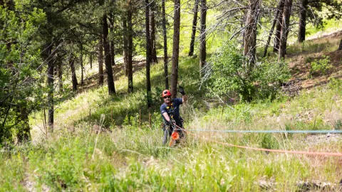 SURF ERT Member Dennis Schmidt rappels down a steep slope to retrieve trash during the 2026 clean-up day.  